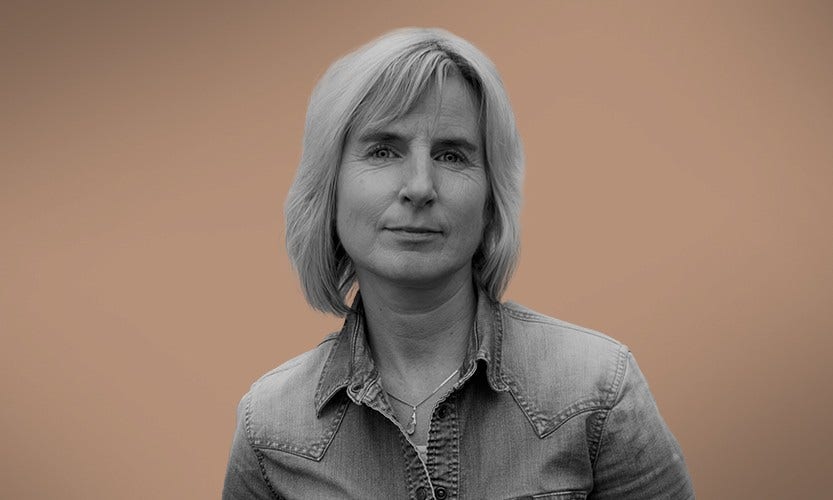 Människor som står och tittar på en brasa utomhus vid en sjö