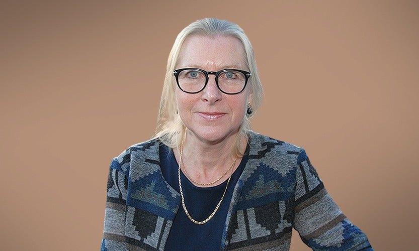Människor som står och tittar på en brasa utomhus vid en sjö