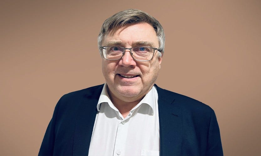 Människor som står och tittar på en brasa utomhus vid en sjö
