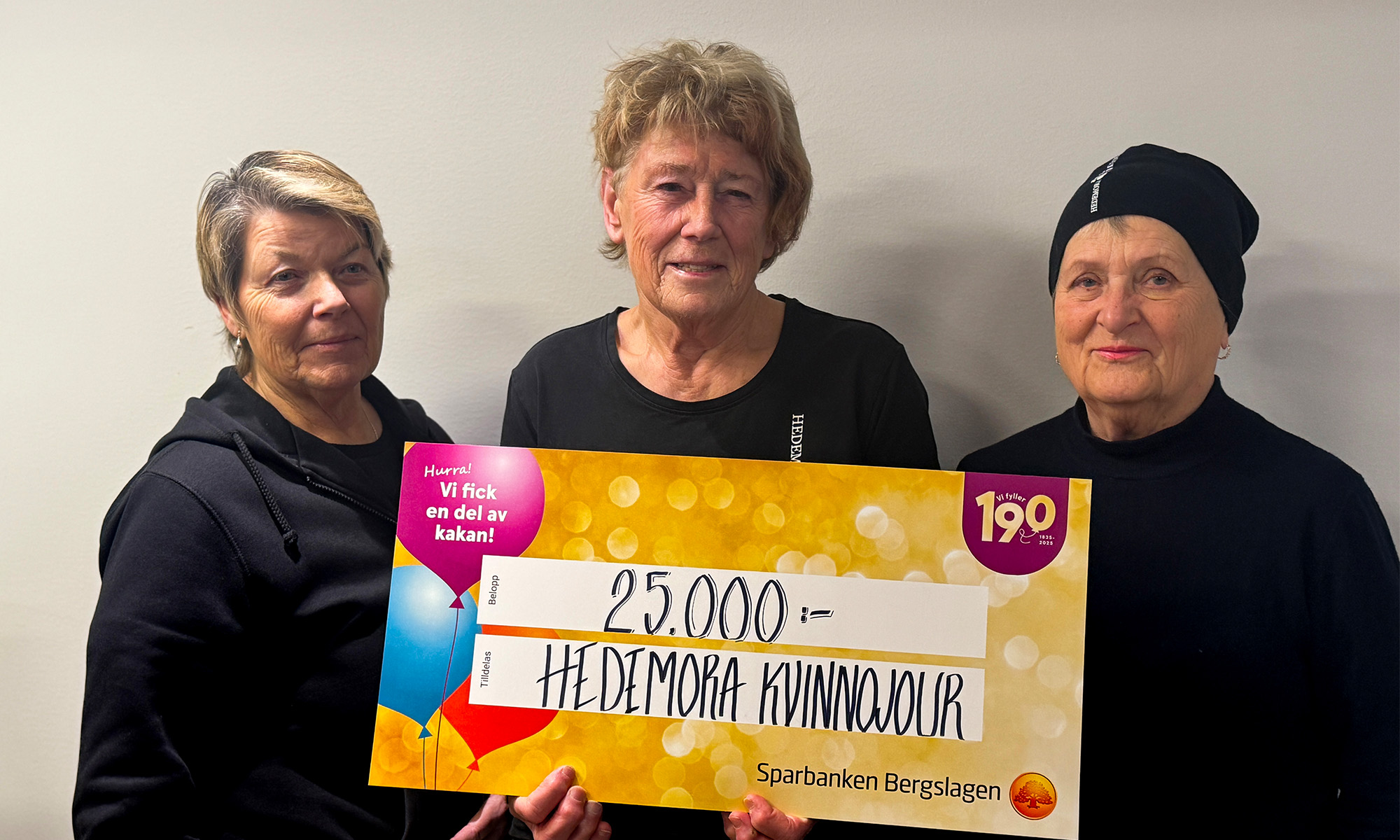 Kvinnor Hedemora Kvinnojour håller upp en värdecheck på 25 000 kr.