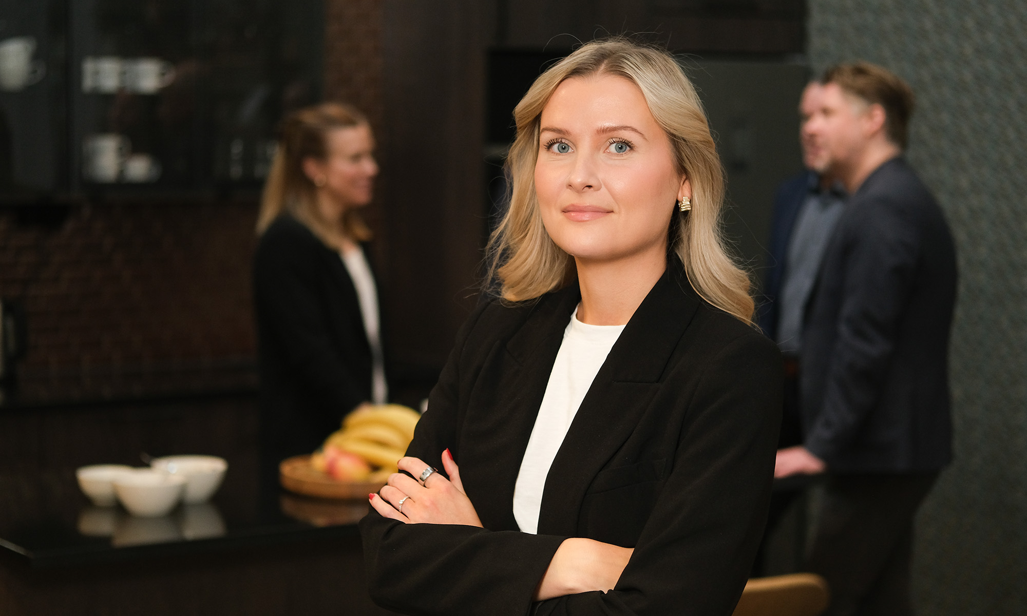 Ung kvinna som står med armarna i kors och ser in i kameran