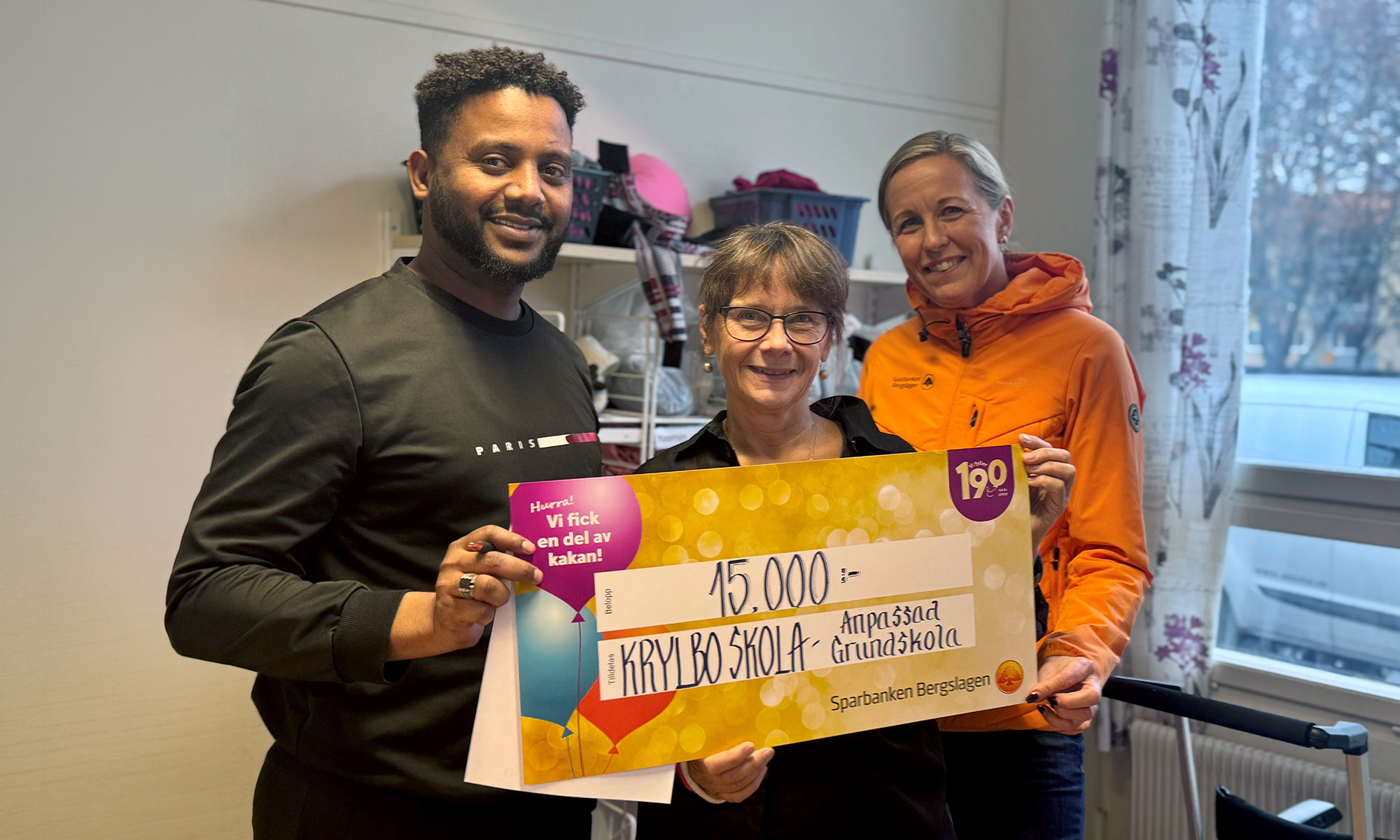 Medarbetare från Krylbo skola håller upp sin värdecheck på 15 000 kr.