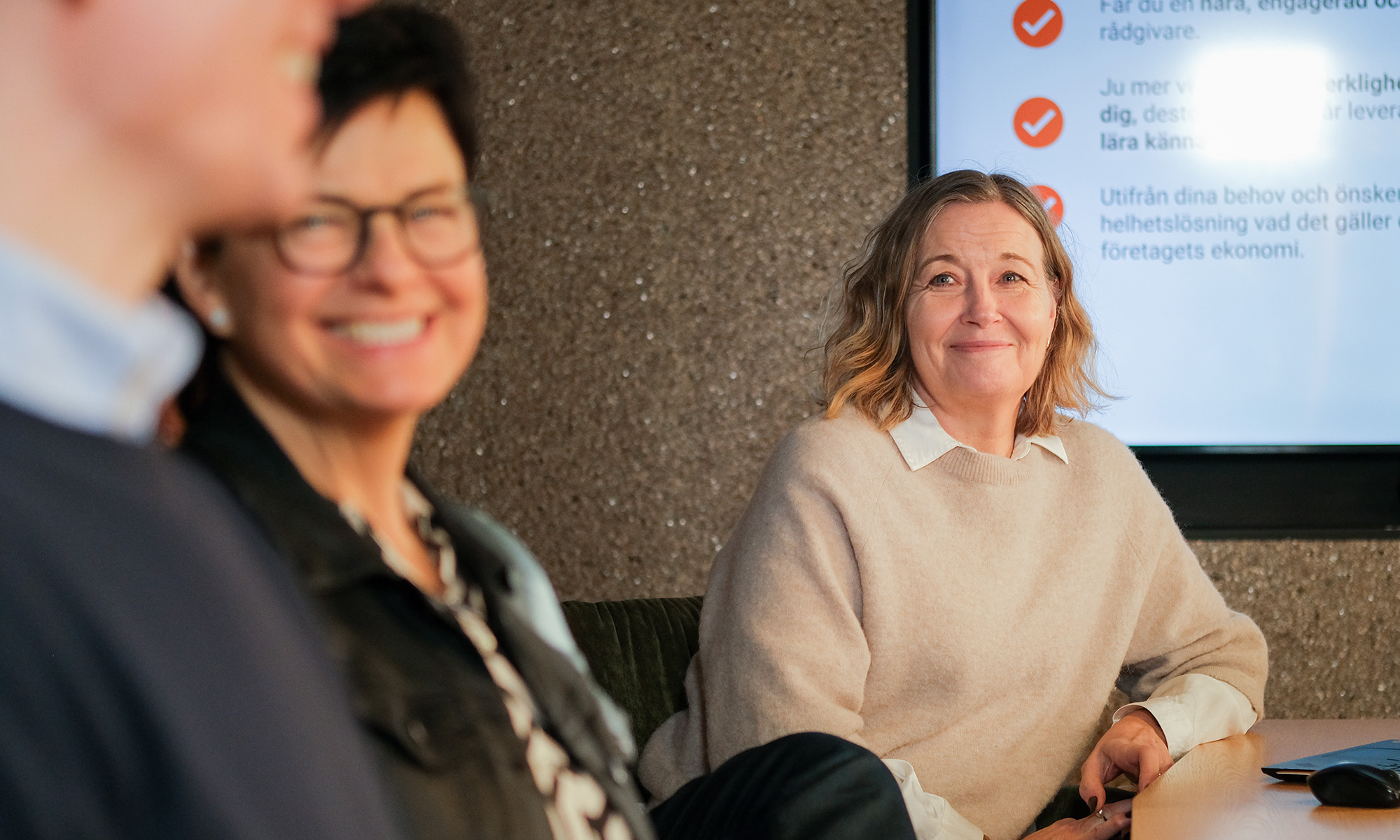 Tre kollegor sitter i sammanträde..