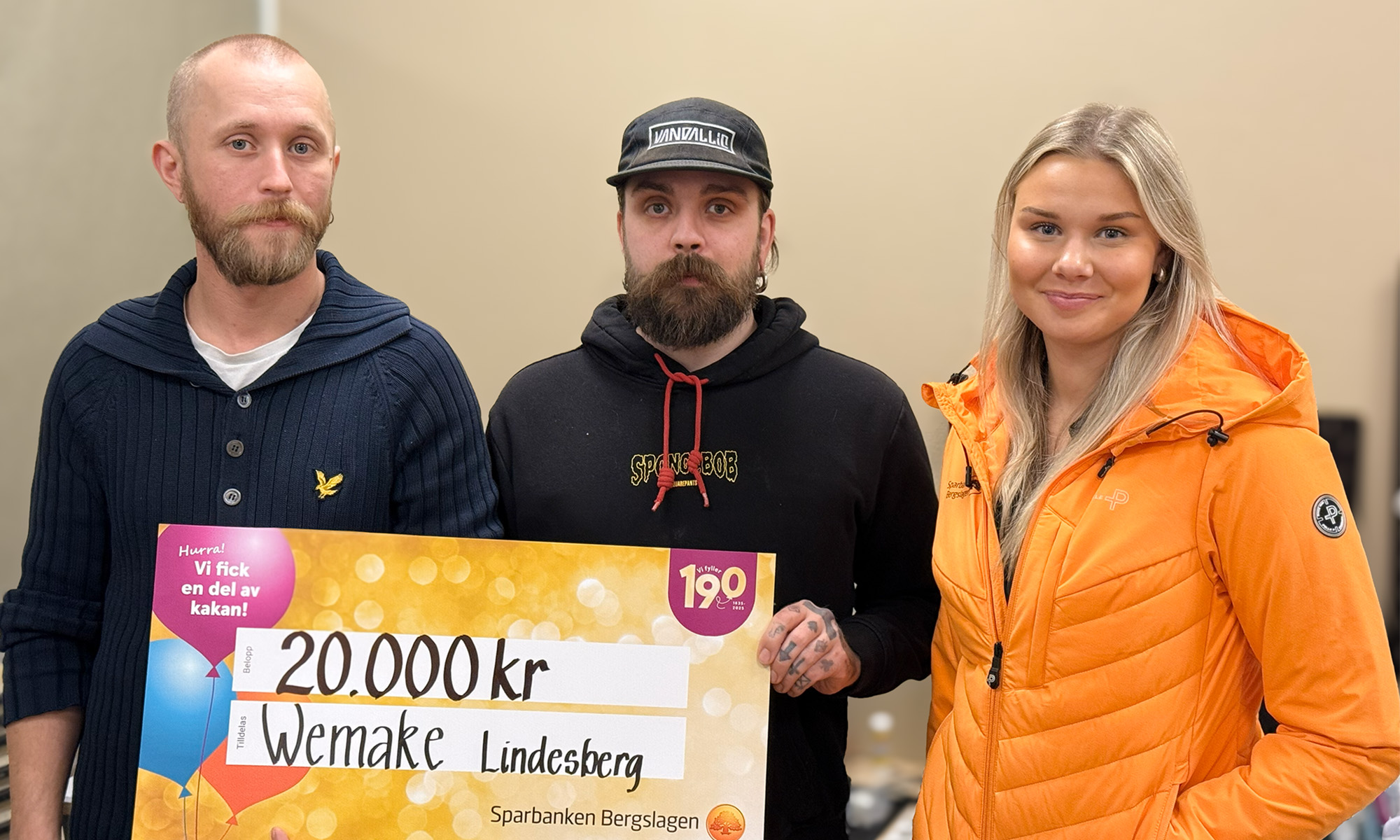 Två killar från Wemake håller upp en värdecheck på 20 000 kr