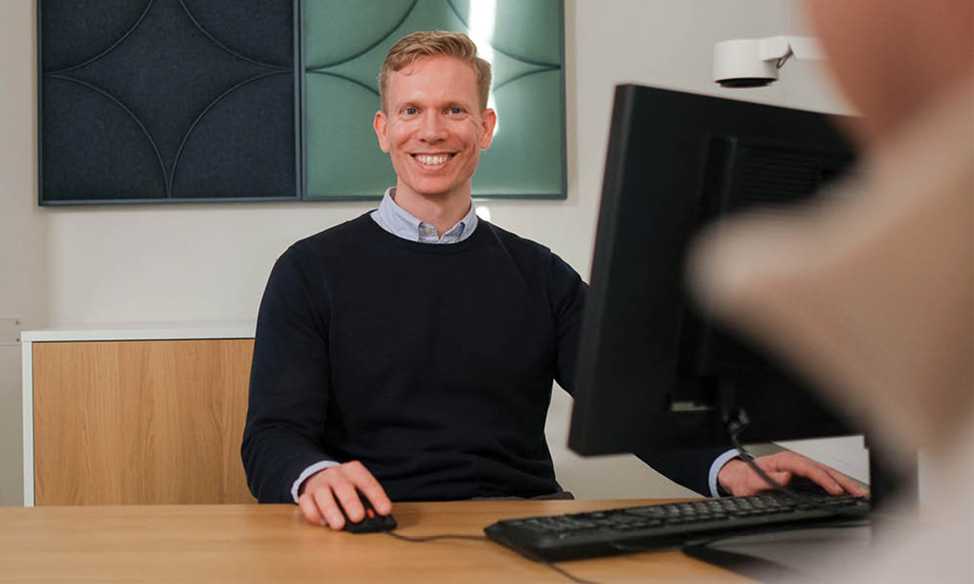 Private Banking rådgivare som sitter vid sitt skrivbord.
